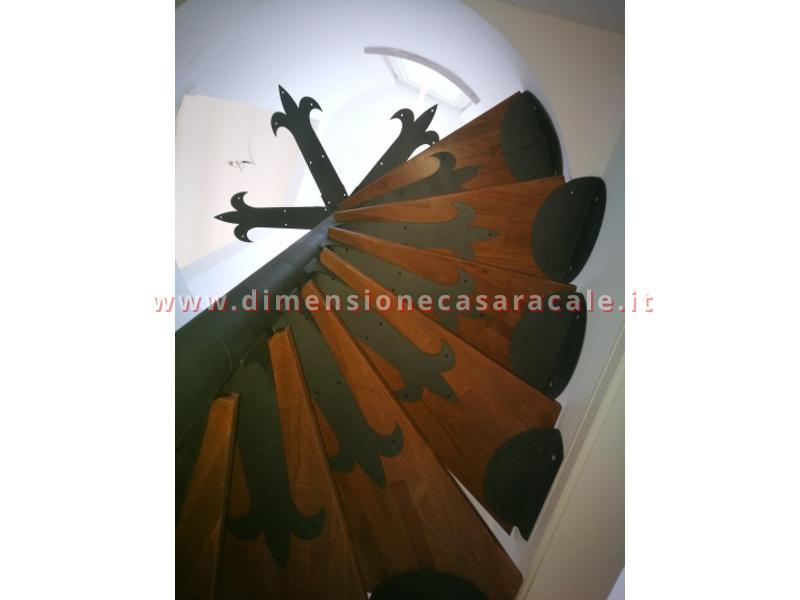 Realizzazione su misura di scala a chiocciola da interno con struttura metallica e gradini in legno taglio laser e ferro battuto 16